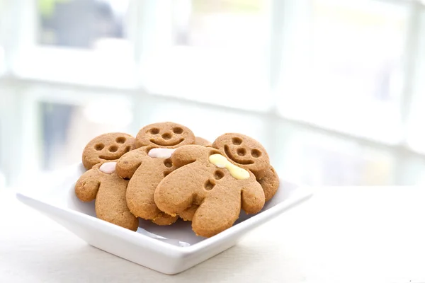 Freshly baked gingerbread biscuits in white plate — Stock Photo, Image