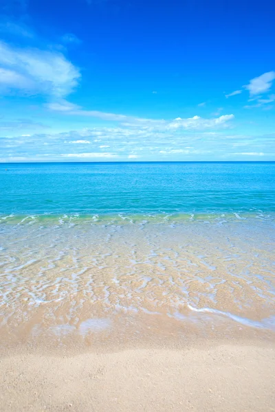 Beautiful sandy beach with calm water against blue skies. Stock Photo ...