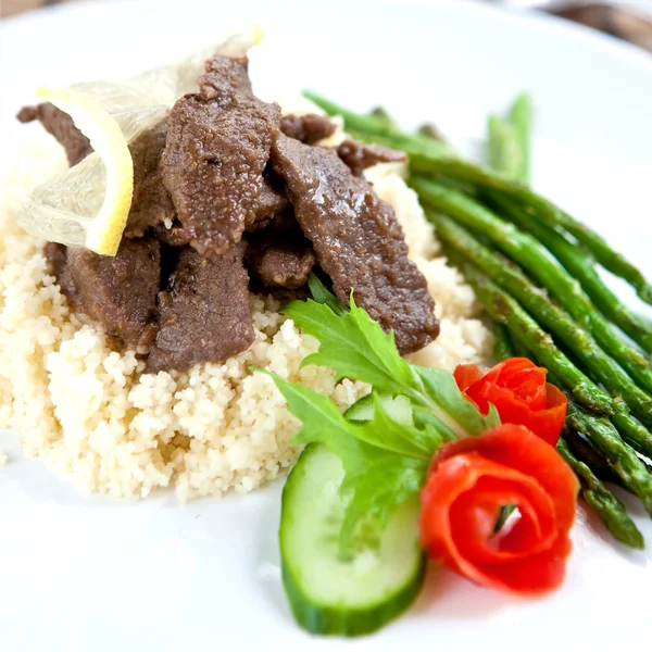 Lamb cous cous with grilled asparagus — Stock Photo, Image