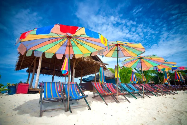 Colorful sun parasols and sundeck chairs on beautiful white sandy beach — Stock Photo, Image