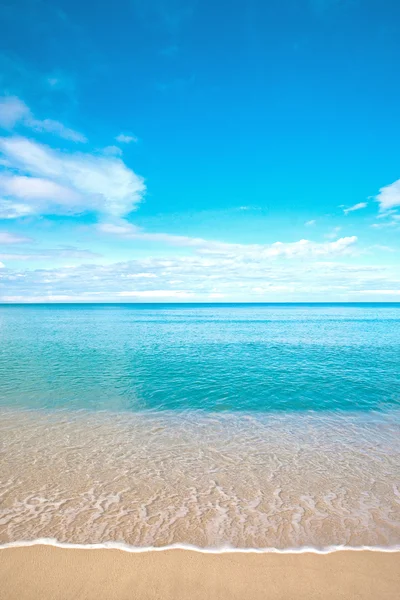 Bella spiaggia di sabbia con acqua calma contro il cielo blu . — Foto Stock