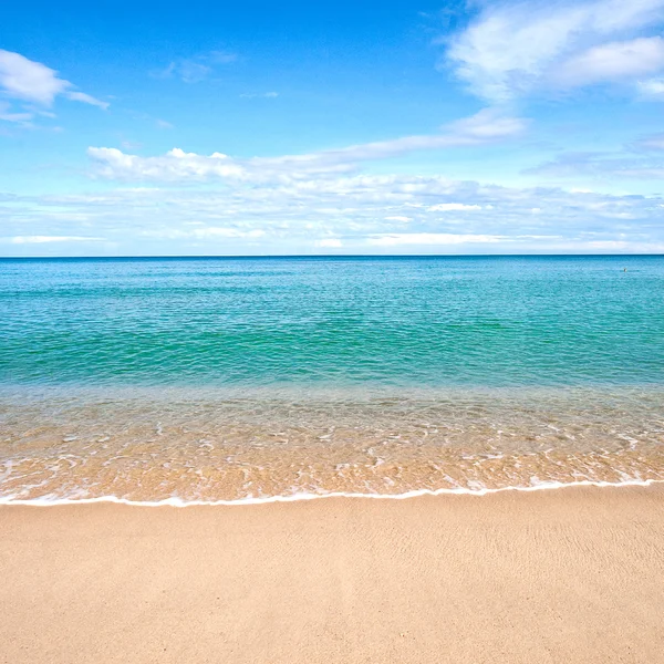 Песчаный пляж со спокойной водой на фоне голубого неба . — стоковое фото
