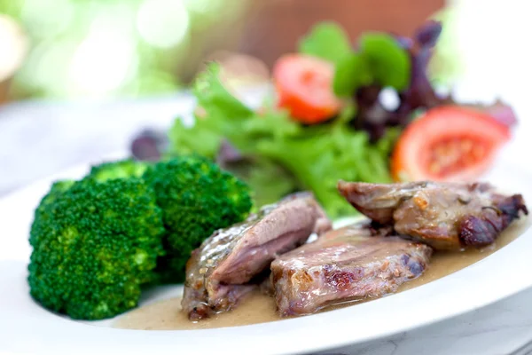 Geroosterd lamsvlees met saus geserveerd met broccoli en salade — Stockfoto