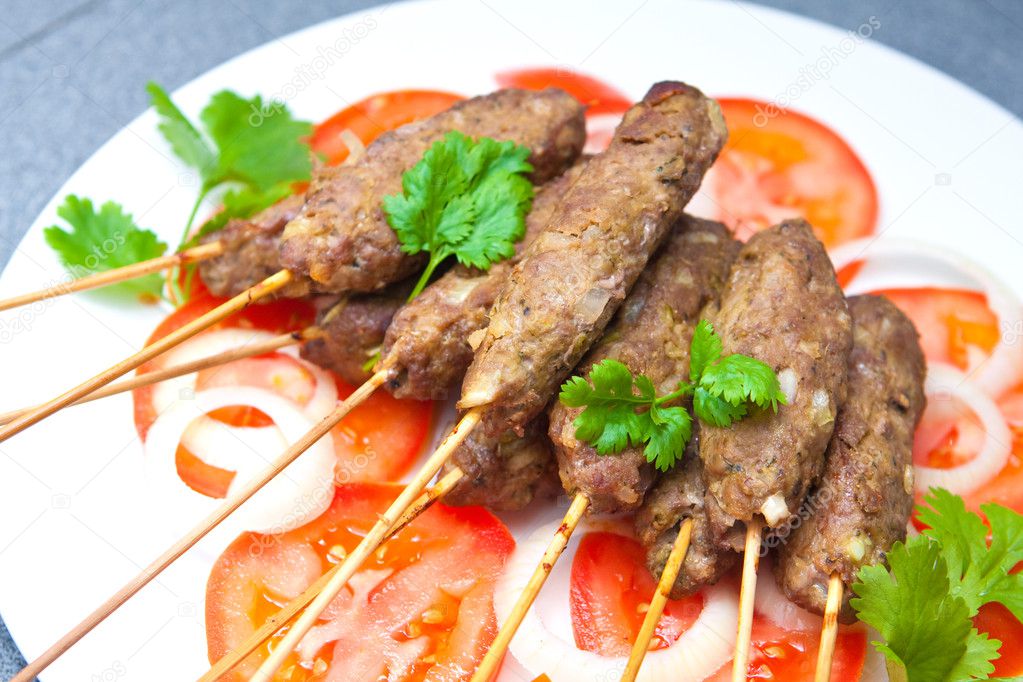 Delicious lamb seekh kebabs served with rice and tomatoes
