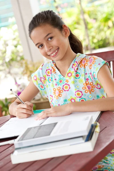 Krásná mladá dívka dělá její domácí úkoly v domácím prostředí — Stock fotografie