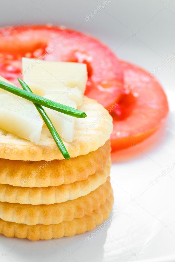 Crackers and cheese with sliced tomatoes