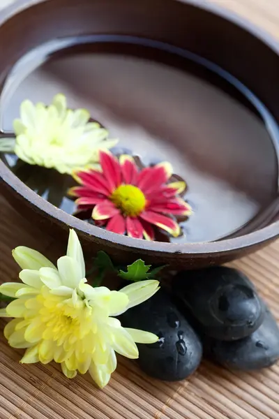Ajuste de spa con piedras calientes con crisantemo y tazón de agua . —  Fotos de Stock