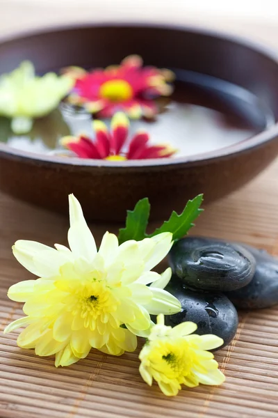 Ajuste de spa con piedras calientes con crisantemo y tazón de agua . — Foto de Stock