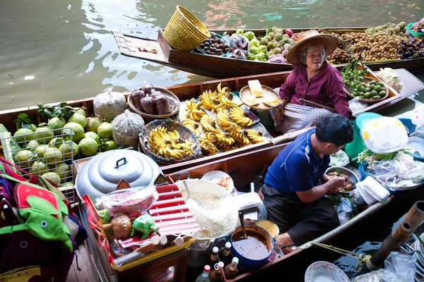 BANGKOK - MAY 2011: Damnoean Saduak floating market, Bangkok Thailand, May 2011. Local women selling fried bananas on wooden boats. — Stock Photo, Image