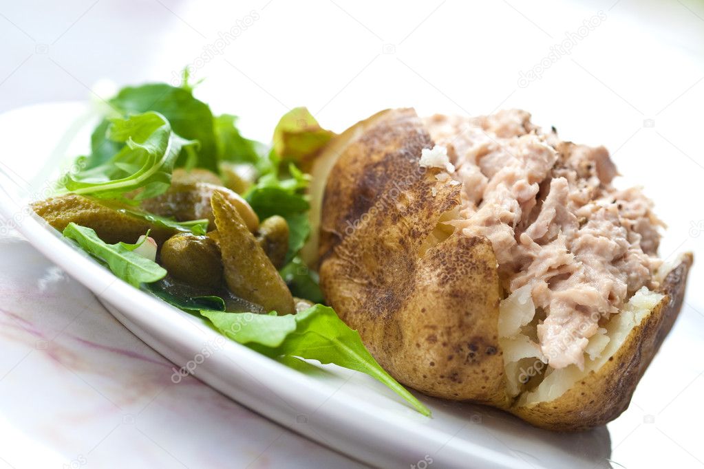 Delicious freshly baked potato served with tuna and salad