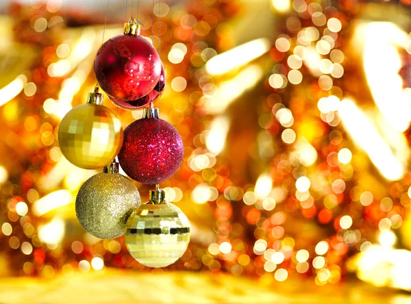 Gold Christmas decoration on red bokeh background — Stock Photo, Image