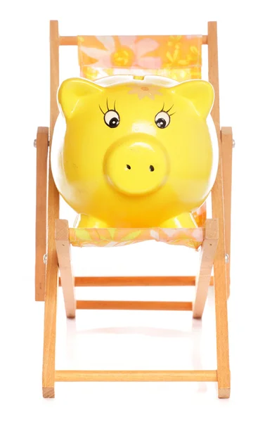 Piggybank amarelo na cadeira de praia — Fotografia de Stock