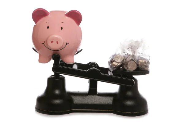 Banco porquinho em balanças com dinheiro esterlina — Fotografia de Stock