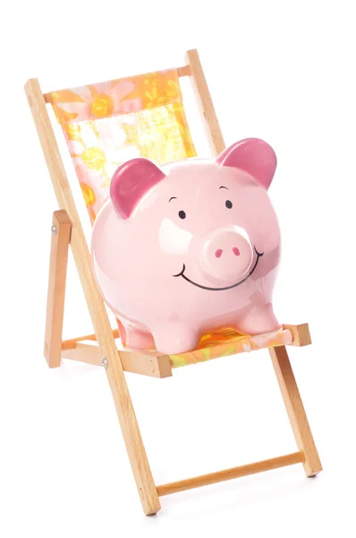 Piggy bank on deck chair — Stock Photo, Image