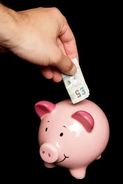 Pessoa economizando dinheiro no banco porquinho — Fotografia de Stock