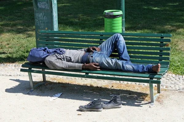 Ubogich na marginesie bezdomny śpi w ławce na zewnątrz — Zdjęcie stockowe