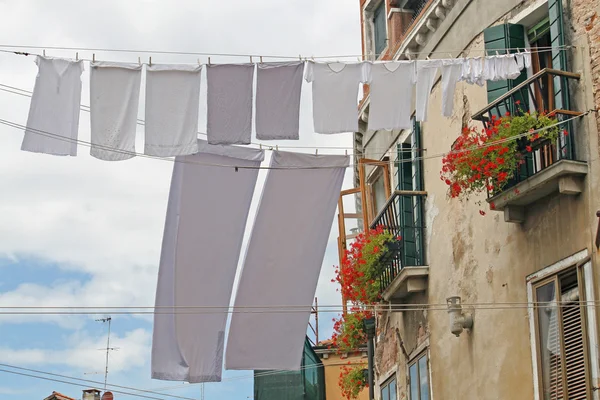 Calle en Venecia con lavado colgado para secar al sol sobre el agua cha —  Fotos de Stock