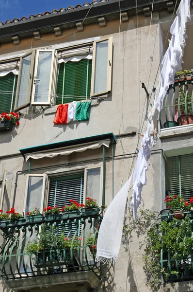 Ropa colgando con la bandera italiana en una casa en Venecia —  Fotos de Stock