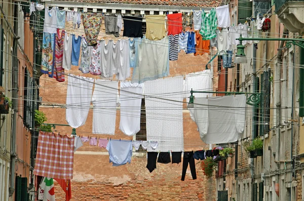 Street in venice with washing hung out to dry in the sun over the water cha — Stock Photo, Image