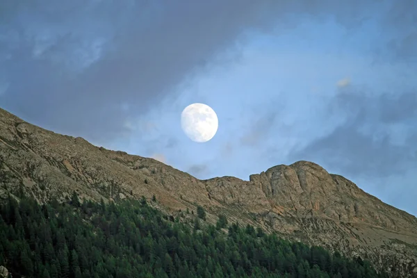 stock image Moon rises over the peaks of the Dolomites mountains in Canazei