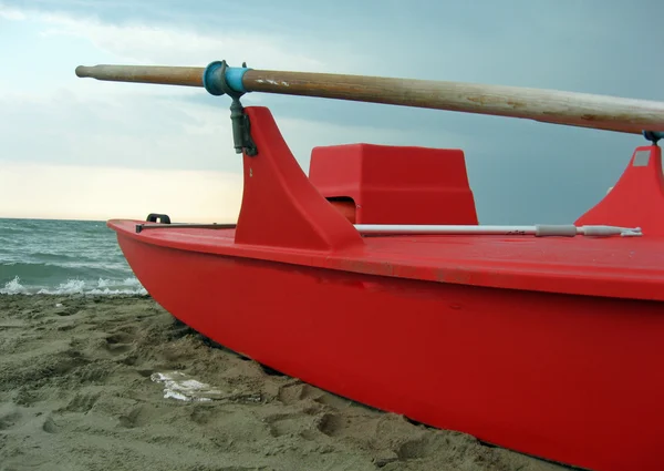 Łódź ratownicza czerwony z wiosła drewniane wzdłuż plaży — Zdjęcie stockowe