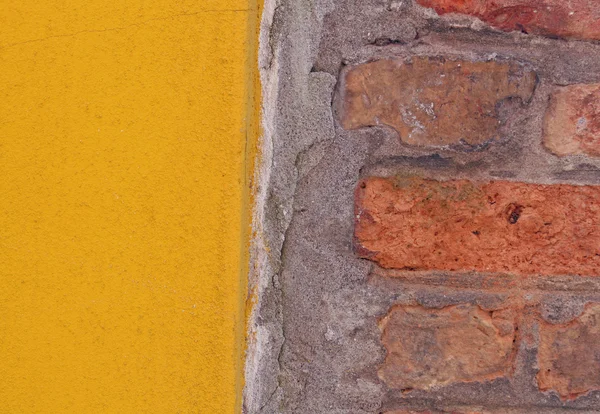 Gele muur in tegenstelling tot de rode bakstenen — Stockfoto