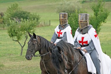 Two medieval crusaders shall strutting with their horses blacks in the Ital clipart