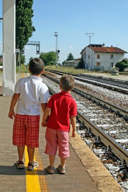 dos hermanos, los niños a la espera de la estación de tren