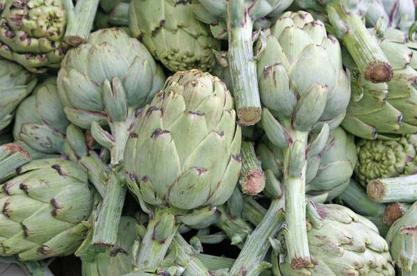 Mature green artichokes with stems in the grocery store sales — Stock Photo, Image