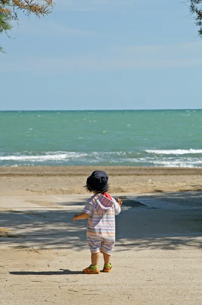 Ребенок смотрит на море в летний день — стоковое фото