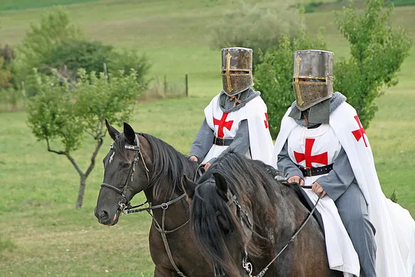 Zwei mittelalterliche Kreuzritter stolzieren mit ihren Pferden Schwarzen im ital — Stockfoto