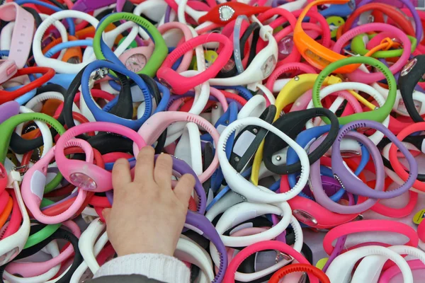 Mano della ragazza che ruba i braccialetti colorati orologi — Foto Stock