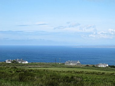 Irish Sea Blue with the houses on the cliff by the sea and the meadow clipart