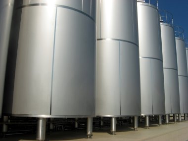 Silos containing liquid inside a factory clipart