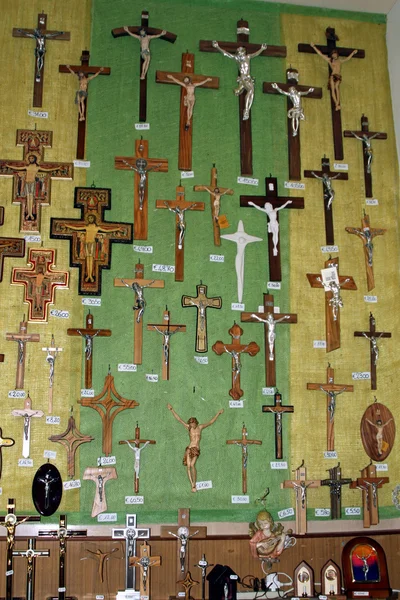 Pared llena de crucifijos a la venta en una tienda en un santuario —  Fotos de Stock