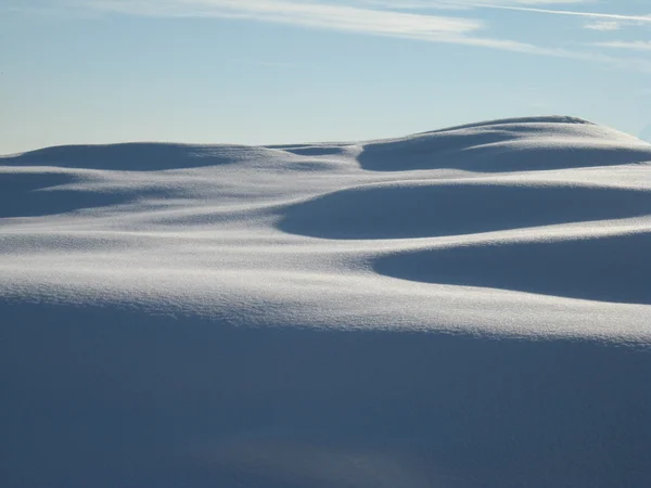 Солнечные дюны свежего снега — стоковое фото