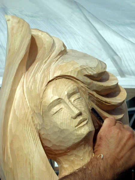 Holzhandwerker, der ein Gesicht schnitzt — Stockfoto