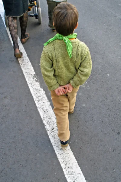 Dziecko beztroski, który chodzi z rękami za plecami — Zdjęcie stockowe