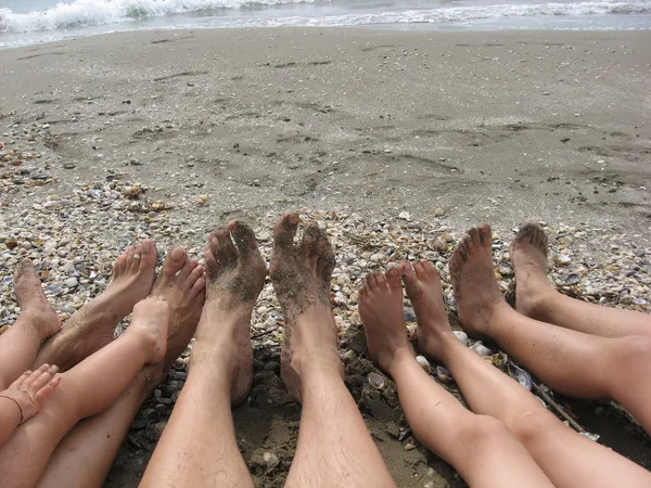 Feet of a family on the beach by the ocean — Stock Photo, Image