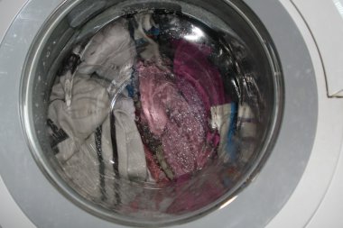 Washing dirty laundry in a washing machine inside home clipart