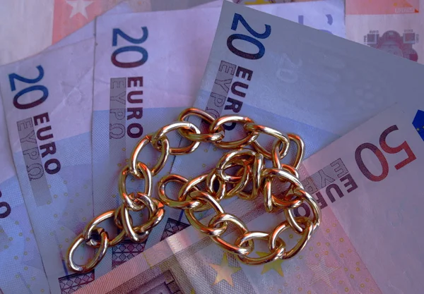 Gold necklace with money in euros in the background — Stock Photo, Image