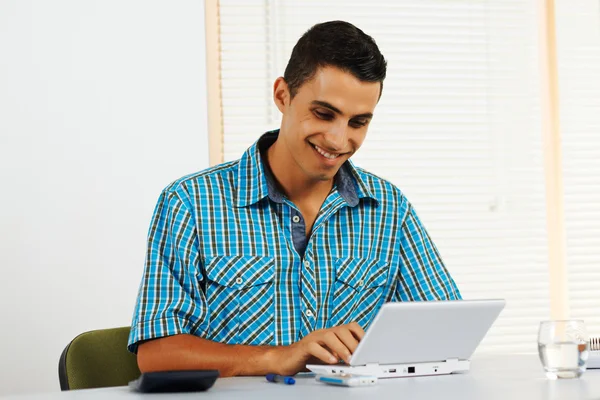 Νεαρός άνδρας, χρησιμοποιώντας ένα φορητό υπολογιστή — Φωτογραφία Αρχείου