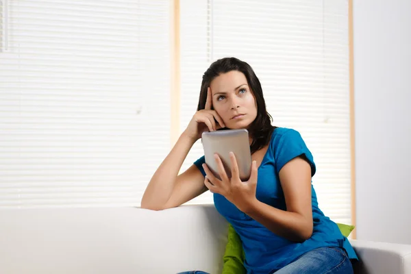 Mujer pensando mientras sostiene una tableta PC — Foto de Stock