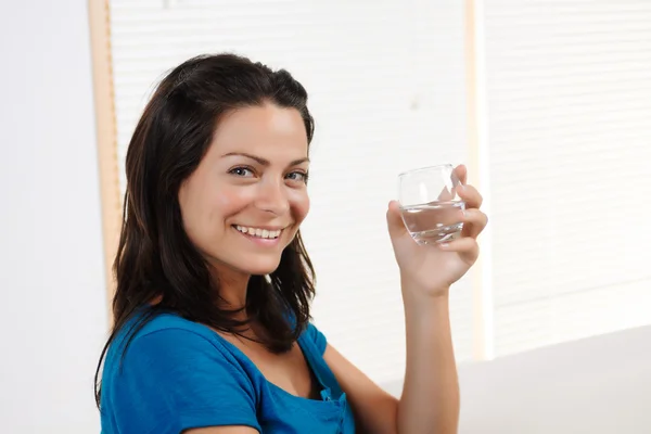 Młoda kobieta uśmiechając się ze szkłem — Zdjęcie stockowe