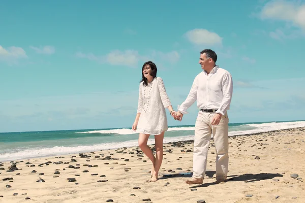 Casal caminhando ao longo da praia — Fotografia de Stock