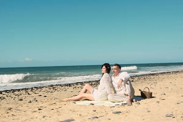 Casal sentar-se na praia — Fotografia de Stock