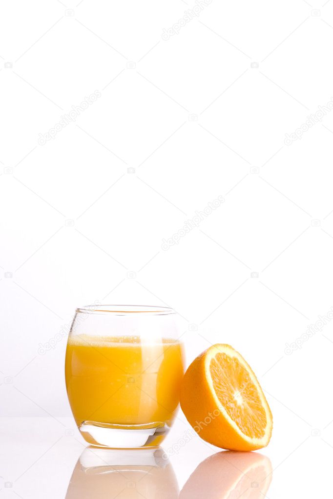 Composition of a glass with a refreshing orange juice and the half of a ora