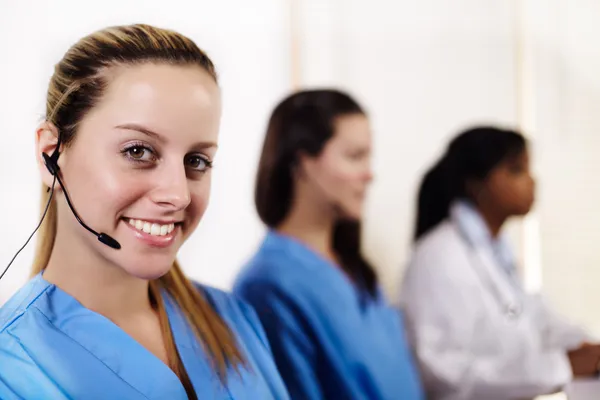 Enfermeira falando em um call center — Fotografia de Stock