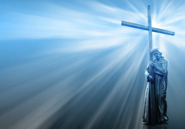 Ježíš drží kříž na modrém pozadí — Stock fotografie