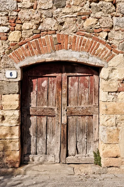Porta de madeira velha em uma parede de tijolo — Fotografia de Stock